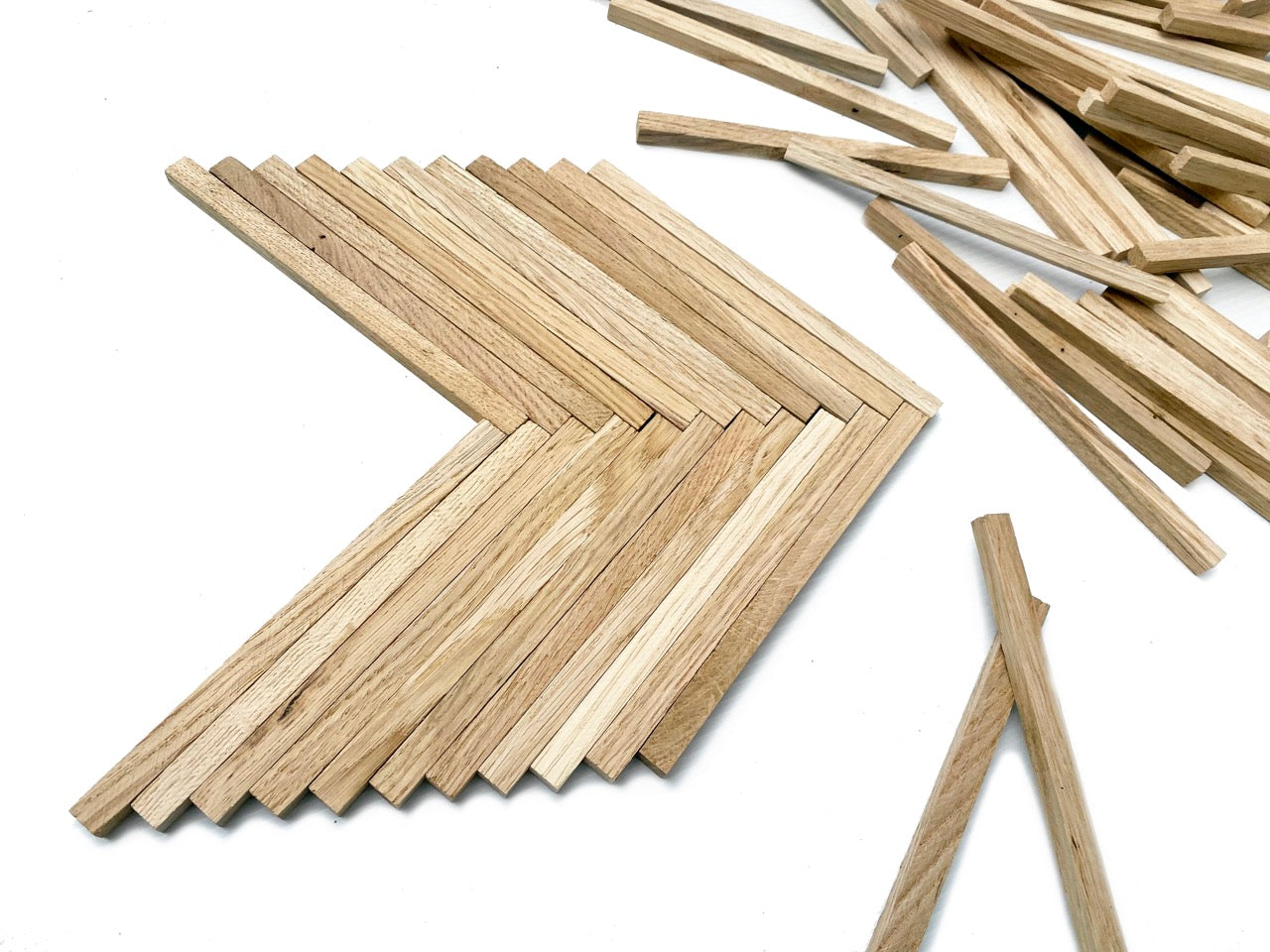 Bastelklötzchen Holzlamellen Eiche aufgefächert neben losen Holzstäbchen